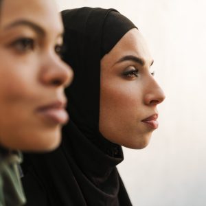 Multiracial muslim women posing and looking asid outdoors